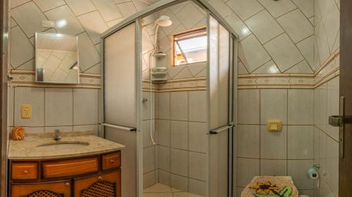 La salle de bains est pourvue d'une douche et d'un lavabo. dans l'établissement Casa 100m da praia, 10 pessoas, 3 quartos, à Bombinhas
