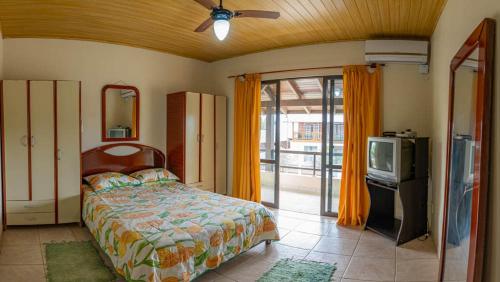- une chambre avec un lit et une télévision à écran plat dans l'établissement Casa 100m da praia, 10 pessoas, 3 quartos, à Bombinhas