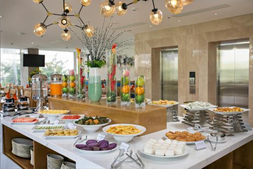 a buffet with many plates of food on a table at Cordial Beach Hotel Da Nang in Da Nang