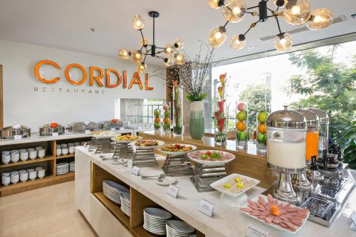 a buffet line with food on it in a restaurant at Cordial Beach Hotel Da Nang in Da Nang