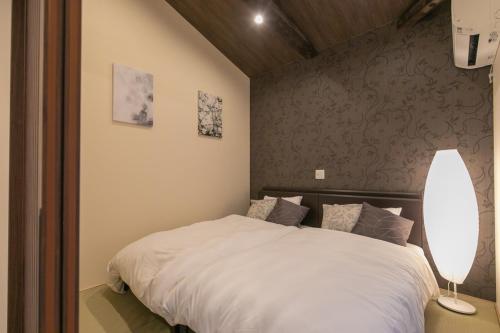 Een bed of bedden in een kamer bij CASA GRApP Nishikujyo