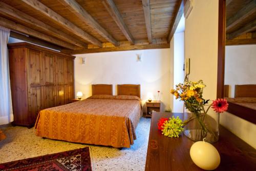 um quarto com uma cama e uma mesa com flores em Camere Di Ulisse em Erice