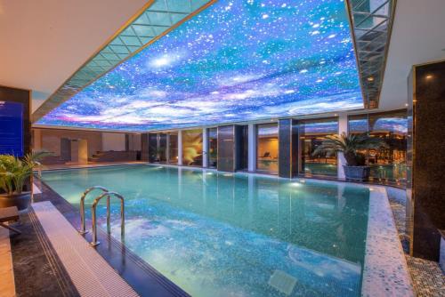 a swimming pool in a building with a star ceiling at Wyndham Garden Hanoi in Hanoi