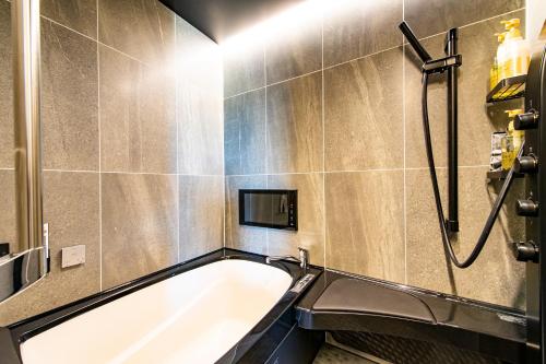 伊万里市にあるHOTEL WINの浴槽とシャワー付きのバスルーム