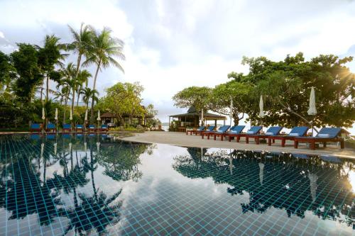 a pool at a resort with lounge chairs and trees at Chaweng Buri Resort in Chaweng