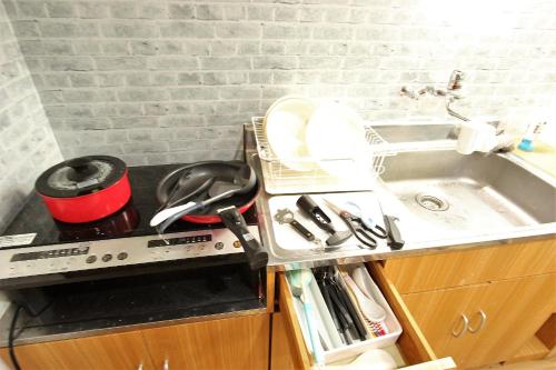 a kitchen counter with a sink and a utensil at Wayado Sapporo Ciao in Sapporo