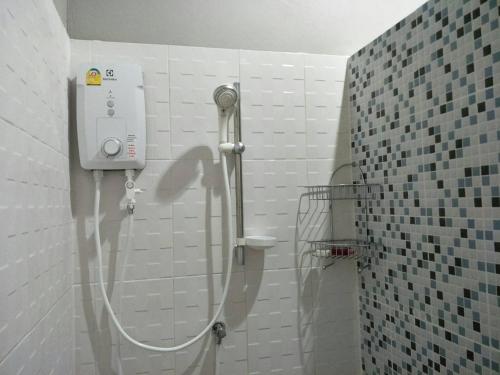 a shower in a bathroom with a white tiled wall at No.17 @ Khaoyai in Mu Si