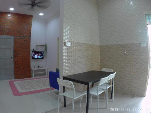 a dining room with a black table and chairs at Holiday Homestay Dungun in Dungun