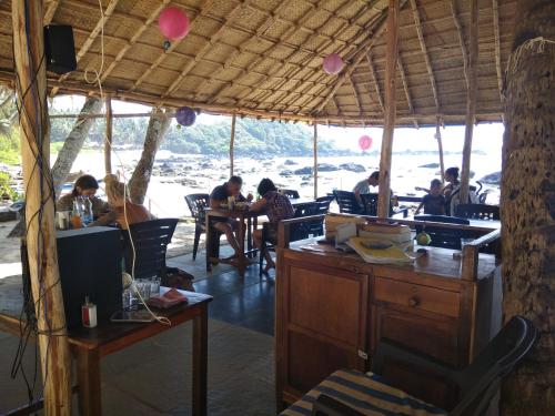 un gruppo di persone seduti ai tavoli in un ristorante di Cola Beach Sunset Bay a Cola