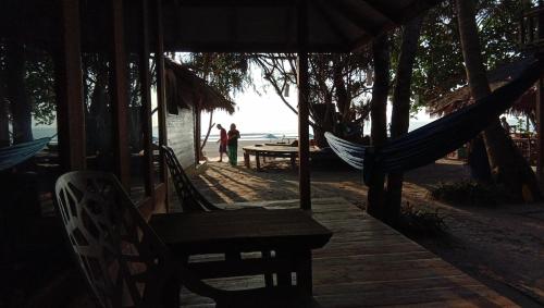 two people standing in a hammock on the beach at Lazy Hut in Ko Phayam