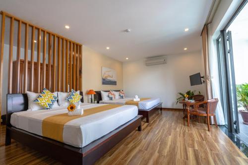 a hotel room with two beds and a couch at Golden Star Villa Hoi An in Hoi An