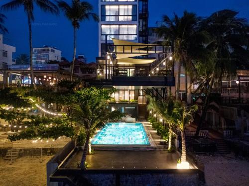 M Hotel Phu Quoc في فو كووك: مبنى فيه مسبح بالليل