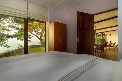 um quarto com uma cama e uma grande janela em The Buena Vista Kandy em Kandy