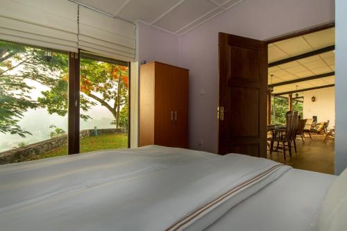 a bedroom with a bed and a large window at The Buena Vista Kandy in Kandy