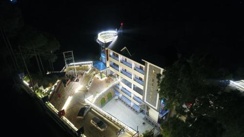 a building with a clock tower on top of it at night at Kanishka Retreat Resort Chail in Chail