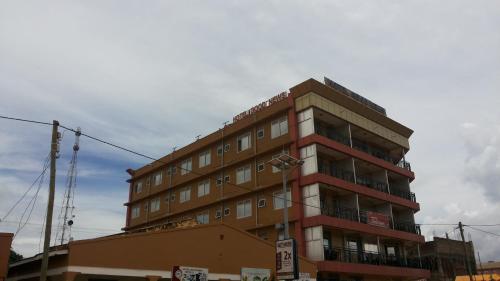 um edifício tallartment com um sinal em frente em Hotel Good News em Lira