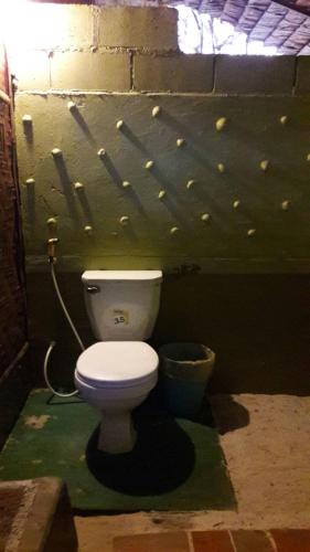 a bathroom with a white toilet in a room at Lazy Hut in Ko Phayam