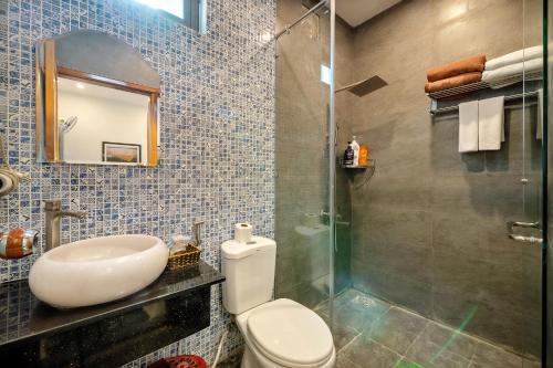 a bathroom with a toilet and a sink and a shower at Lang Dong An Bang in Hoi An