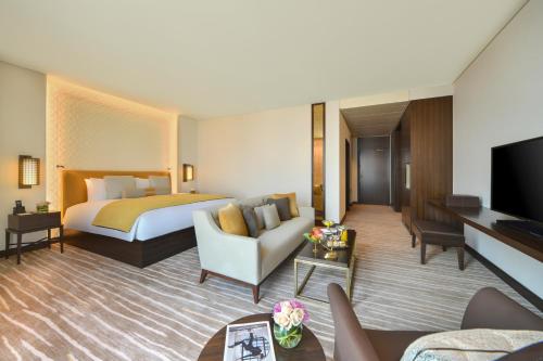 a hotel room with a bed and a living room at Alwadi Hotel Doha - MGallery Collection in Doha