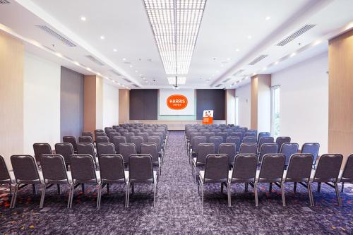 a room with rows of chairs and a screen at HARRIS Hotel & Conventions Bundaran Satelit Surabaya in Surabaya
