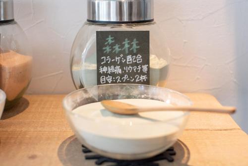 a bowl with a wooden spoon on a table with a bottle at Uwajima Oriental Hotel in Uwajima