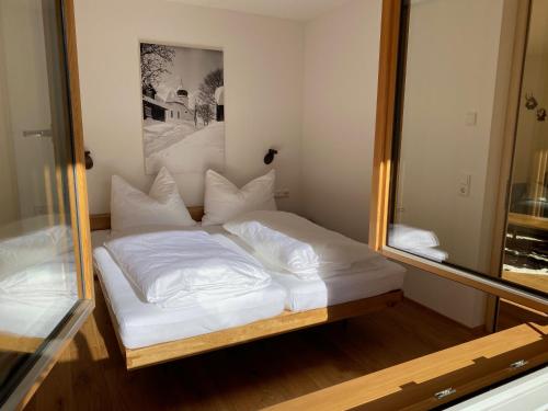 a bed in a room with a large mirror at Landhaus Bergpanorama TOP 7 in Damuls