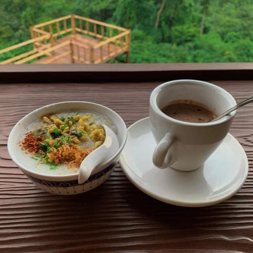 a bowl of soup and a cup of coffee on a table at ม่านฟ้า โฮมสเตย์ MaanFah Homestay in Chiang Rai