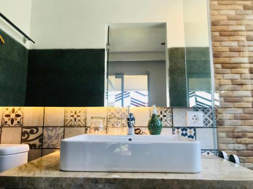 a bathroom with a white sink and a mirror at Radha Homestay in Sanur