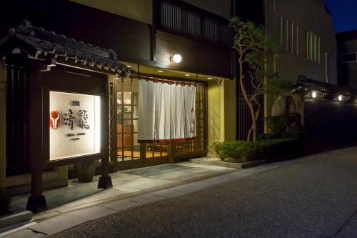 a building with a sign in front of it at night at Ryokan Seiryu (Specialised in Hida beef) in Takayama