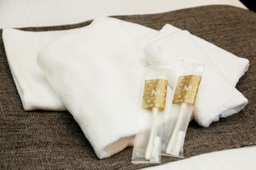 two white towels and two candles on a table at M's Hotel Kyoto Station Kizuya in Kyoto