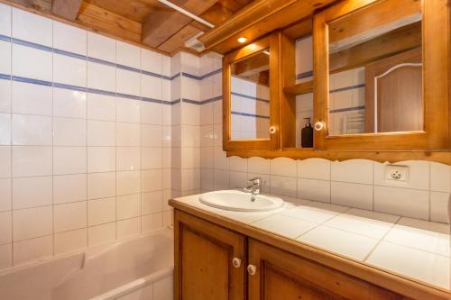 une salle de bain avec un lavabo, un miroir et une baignoire dans l'établissement Polaris - Chamonix, à Chamonix-Mont-Blanc
