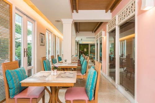 ein Restaurant mit Holztischen und blauen Stühlen in der Unterkunft La Petite Salil Sukhumvit Thonglor 1 in Bangkok
