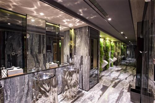 a lobby of a hotel with marble walls and stools at arTree hotel in Taipei