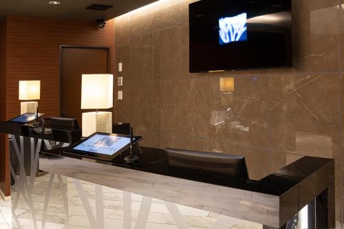 a hotel lobby with a television on the wall at Place Hotel Ascot in Kumamoto