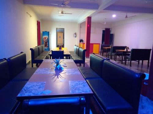 een eetkamer met een lange tafel en stoelen bij Hotel the Ideal in Kushinagar