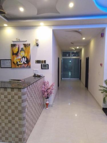a hallway of a building with a counter and flowers at Hotel the Ideal in Kushinagar