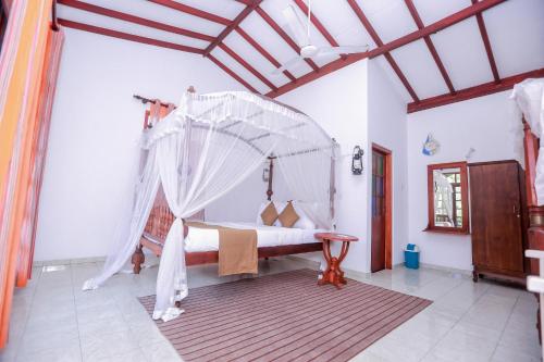 a bedroom with a canopy bed in a room at DANDELION - Unawatuna in Unawatuna