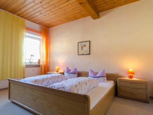 a bedroom with a bed with two night stands and two lamps at Ferienwohnung Hertel in Mistelgau