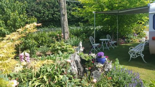 a garden with a table and chairs and flowers at Dragonflycottagebnb in Grovetown