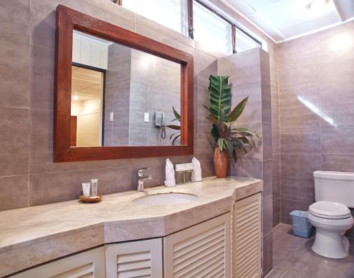 麥克坦的住宿－宿霧白沙度假及Spa酒店，一间带水槽、镜子和卫生间的浴室