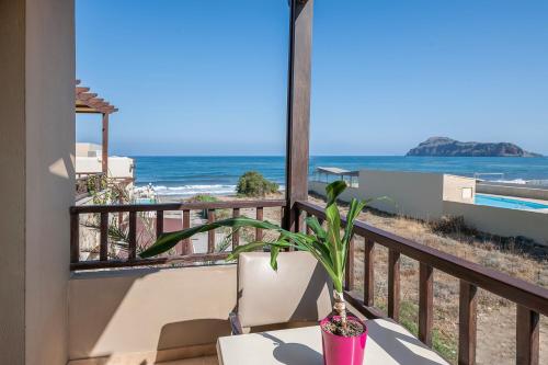 a potted plant on a balcony with a view of the ocean at Indigo Mare in Plataniás