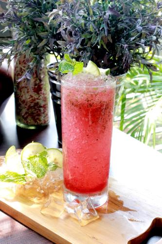 a drink in a glass sitting on a cutting board at Forbis Hotel in Serang