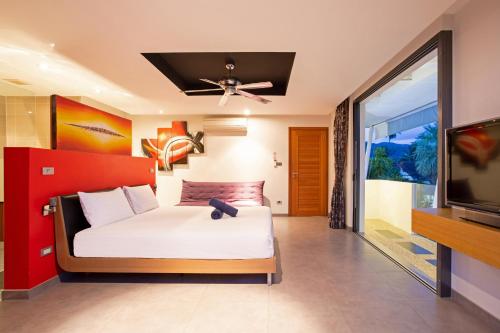 a bedroom with a bed and a flat screen tv at Chic Villa Kloua with Private Pool, 3BR, Close to BCIS in Chalong 