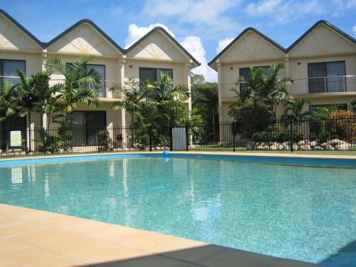 a swimming pool in front of a building at Hinchinbrook Resorts Management Pty Ltd in Lucinda