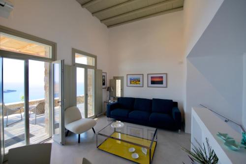 ein Wohnzimmer mit einem blauen Sofa und einem Glastisch in der Unterkunft Ammoa Panorama in Alona