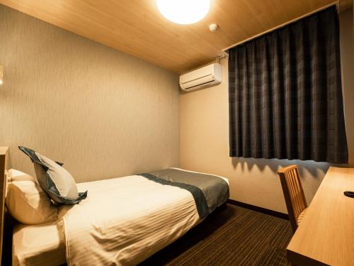 a hotel room with a bed and a window at Hotel AreaOne Izumo in Izumo