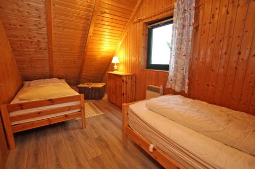ヴィーク・アウフ・リューゲンにあるFerienhaus Wiek RUeG 1541の木造キャビン内のベッドルーム1室(ベッド2台付)