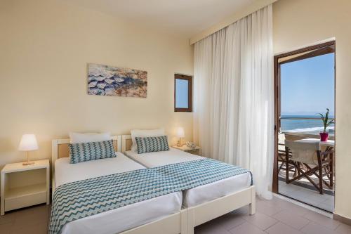 a bedroom with a bed with a view of the ocean at Indigo Mare in Plataniás