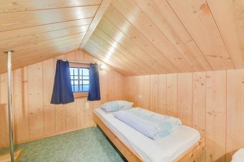 a bed in a wooden room with a window at Ferienwohnung Morgenrot in Wackersberg