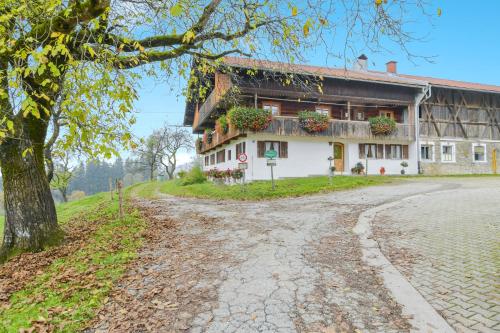 a house on a hill next to a road at Ferienwohnung Morgenrot in Wackersberg